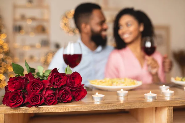 Homem negro jantando com mulher, foco em rosas — Fotografia de Stock