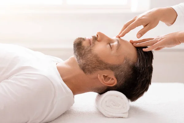 Masseuse handen wrijven slapende man van middelbare leeftijd voorhoofd, close-up — Stockfoto