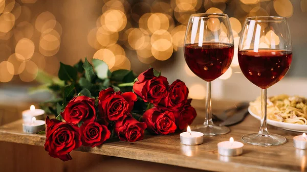 गुलाब, डेस्क पर लाल शराब और मोमबत्तियों के दो ग्लास — स्टॉक फ़ोटो, इमेज