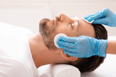 Orta yaşlı adam güzellik kliniğine gidiyor, yüz bakımı konsepti.