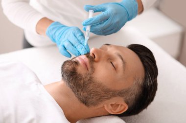 Çekici beyaz adam estetik kliniğe gidip dudaklarını dolduruyor.