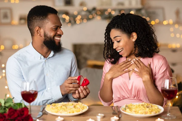 Smiling black man making proposal with ring to his fiance — Stock Photo, Image