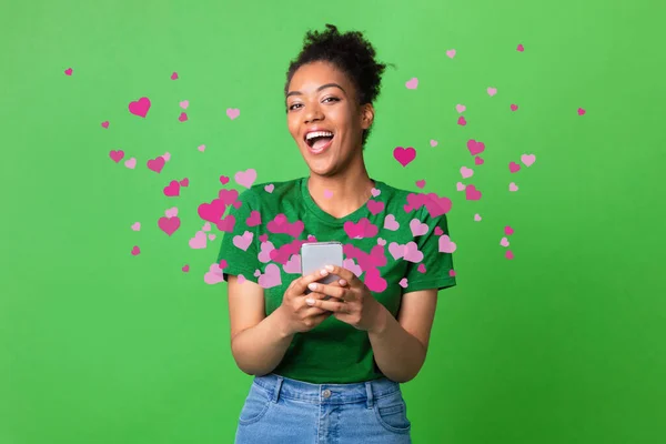 Black woman receiving love message on smartphone, hearts flying away — Stock Photo, Image