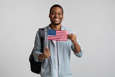 Sırt çantalı, Amerikan bayrağı taşıyan pozitif siyah bir adam.