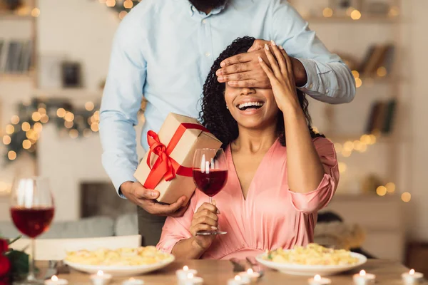 Black man giving box to woman, covering eyes — Stock Photo, Image