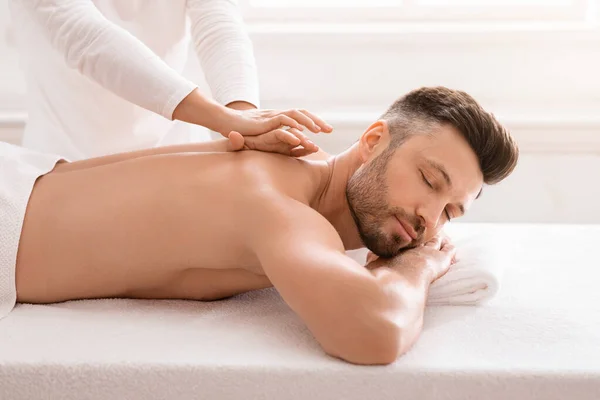 Seitenansicht eines entspannten Mannes mit Körpermassage im Spa — Stockfoto