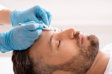 Çekici bir adam güzellik salonunda yüzünü temizliyor.