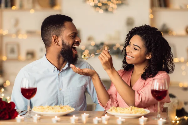 Sorrindo mulher negra alimentando seu homem em um encontro — Fotografia de Stock