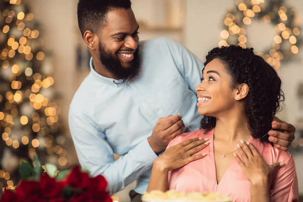 Smiling young black man wearing necklace on his woman — Stock Photo, Image