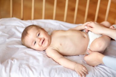 Sevimli bebek eğlenirken anne altını değiştiriyor.