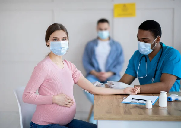 Těhotná žena v lékařské masce, která dostává v nemocnici injekci vakcíny Covid-19. Koncepce zdravotní péče a očkování — Stock fotografie