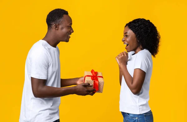 Amante hombre afroamericano dando regalo a su excitada esposa — Foto de Stock