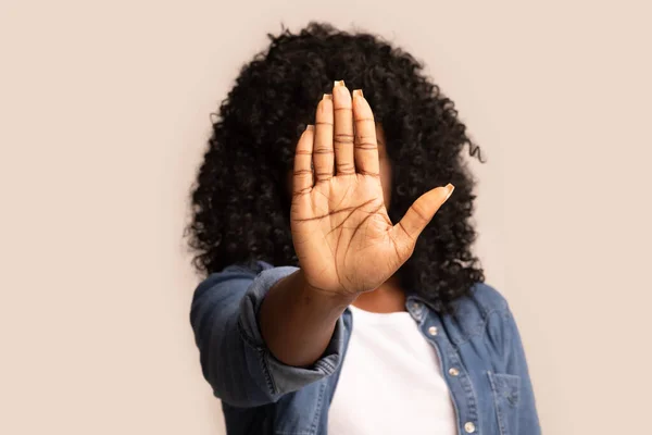 Donna nera mostrando il suo palmo, nascondendo il viso dalla fotocamera — Foto Stock