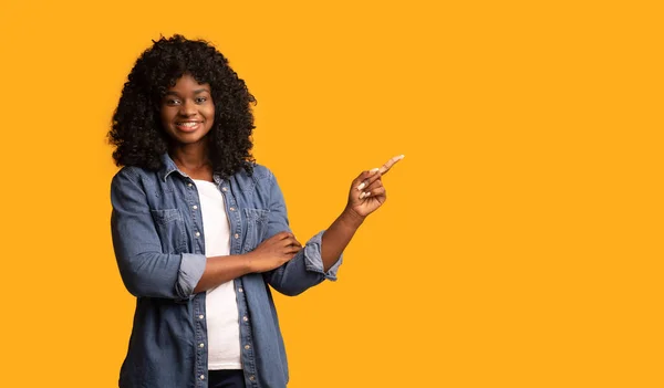 Senhora africana alegre mostrando espaço vazio para propaganda — Fotografia de Stock