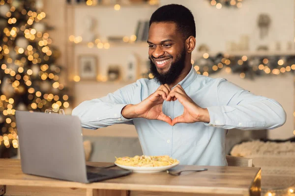 Negro hombre teniendo vídeo llamada mostrando corazón gesto — Foto de Stock