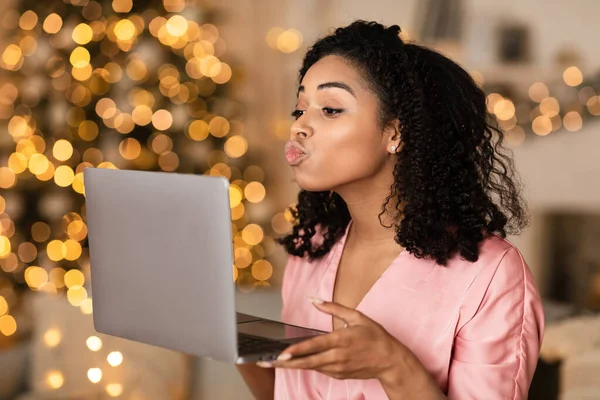Black woman blowing kiss during virtual date on laptop — Stock Photo, Image