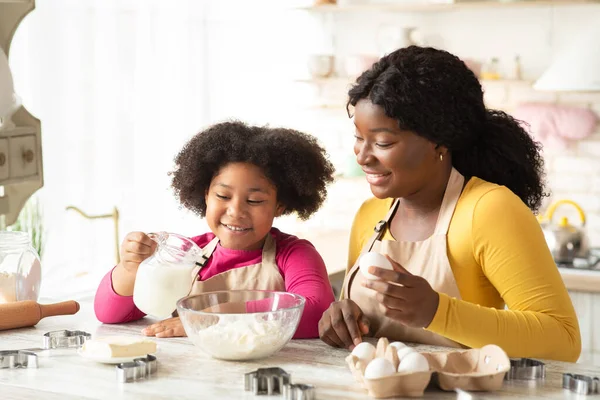 Wesoły czarny rodzina matka i córka pieczenia razem w kuchni — Zdjęcie stockowe
