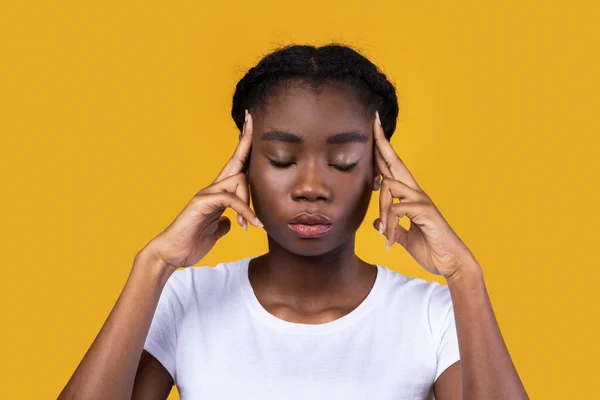 African Female Thinking Massaging Temples With Eyes Closed, Yellow Background — Stock Photo, Image