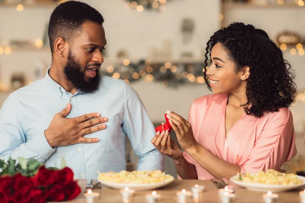 Schwarze Frau macht ihrem überraschten Freund mit Ring einen Heiratsantrag — Stockfoto