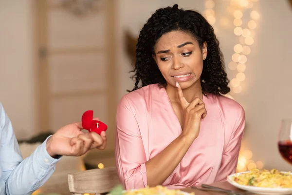 Black man making proposal with ring, woman rejecting