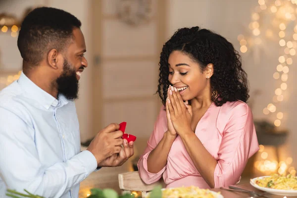 Lächelnder Afro-Mann macht seiner Verlobten einen Heiratsantrag mit Ring — Stockfoto