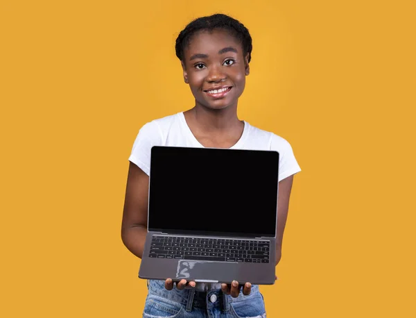 Χαρούμενη Αφρικανική γυναίκα Εμφάνιση laptop κενή οθόνη πάνω από κίτρινο φόντο — Φωτογραφία Αρχείου