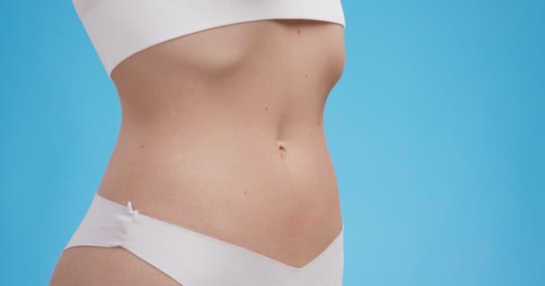 Проблемы с пищеварением. Тонкое женское тело с красным пульсирующим воспалением желудка, синий студийный фон — стоковое видео