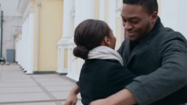 Mutlu Afro-Amerikan erkek ve kadın kucaklaşmaları, beklenmedik bir şekilde dışarıda buluşmaları, ağır çekim