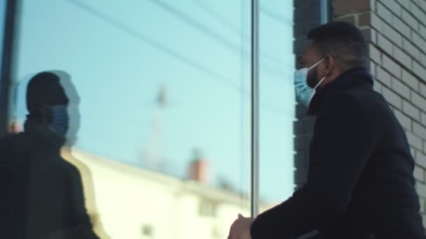 Homme afro-américain en masque de protection regardant par la fenêtre du restaurant, pour savoir si elle est ouverte pendant le coronavirus — Video