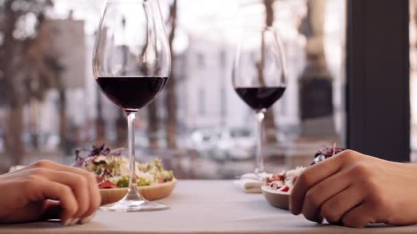 Blisko ujęcia romantycznej pary trzymającej się za ręce w kawiarni, randki w kieliszkach do wina, zwolnione tempo — Wideo stockowe