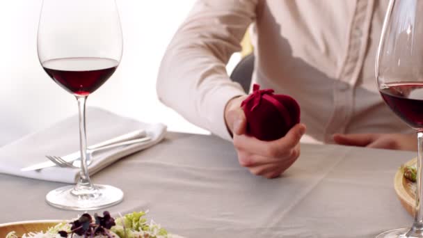 Hombre apertura caja de joyería con anillo de boda, haciendo propuesta inesperada durante la fecha en la cafetería, tiro de cerca — Vídeo de stock