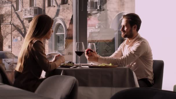 Happy srác eljegyzési gyűrű a meglepett barátnője alatt romantikus randi a kávézóban, lassított felvétel — Stock videók