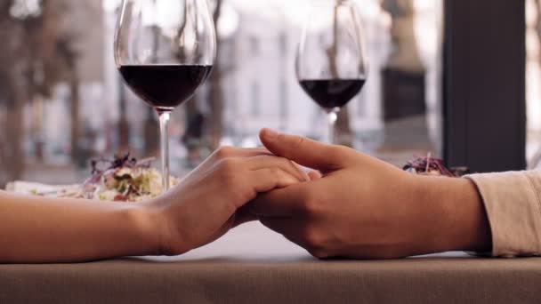 Férfi és nő kéz a kézben, szerelmesek kapcsolat, romantikus randi a kávézóban, közelről — Stock videók