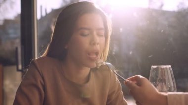 Erkek, kız arkadaşını beslerken, kadın tatlıyı yerken, güneş parlarken, ağır çekimde.