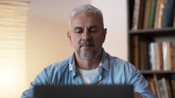 Detailní záběr dospělého muže, který doma pracuje na notebooku, trpí záchvatem bolesti hlavy, masíruje si spánky — Stock video