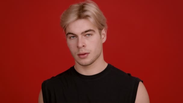 Studio porträtt av snygg blond kille tittar allvarligt på kameran — Stockvideo