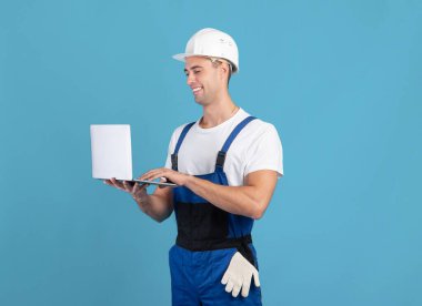 Bilgisayarlı yakışıklı ustabaşı. İnşaat malzemeleri siparişi veriyor.