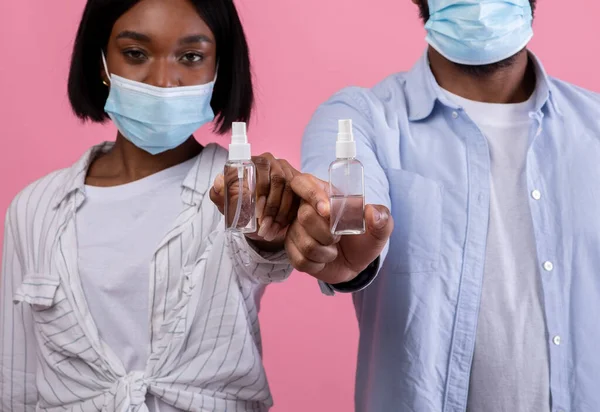 验尸官的保护。两对黑人夫妇展示瓶装清洁剂，推广粉红背景的个人卫生 — 图库照片