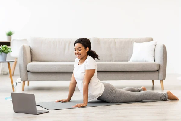 Schwarze Frau übt zu Hause beim Online-Tutorial am Laptop — Stockfoto