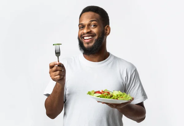 Sorrindo afro-americano cara posando com salada de legumes, fundo branco — Fotografia de Stock