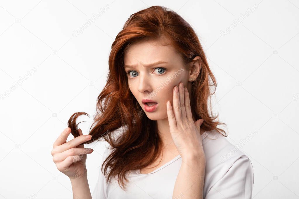 Red-Haired Girl Touching Hair Having Split Ends Problem, White Background