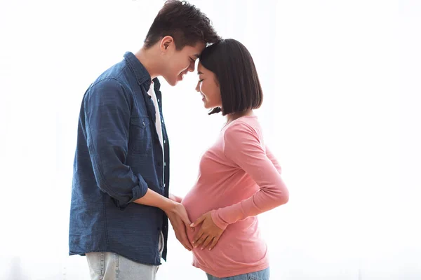 Loving Asian Husband Touching Pregnant Wifes Belly Standing At Home — Stock Photo, Image