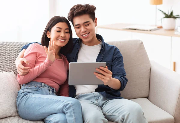 Asijské pár s tablet dělat video hovor online doma — Stock fotografie