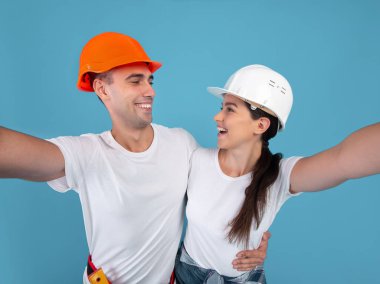 Koruyucu Şapkalı Neşeli Çift Mavi Arkaplan Üzerine Selfie Çekiyor