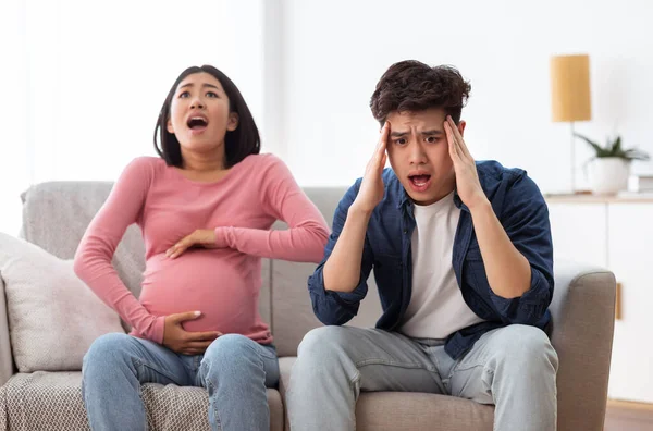 Pregnant Asian Woman Screaming Having Spasm Sitting With Husband Indoors — Stock Photo, Image