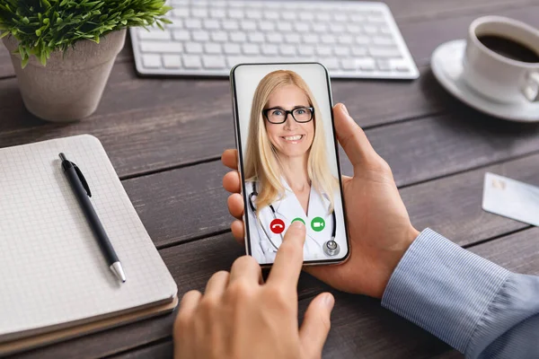 Empresario irreconocible hablando con el médico en línea utilizando la aplicación de chat de vídeo en el teléfono inteligente — Foto de Stock