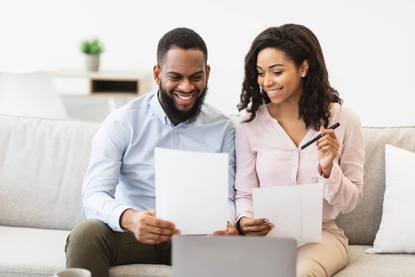 긍정적 인 흑인 남녀가 집에서 합의 사항을 확인하는 문서를 읽고 있다 — 스톡 사진