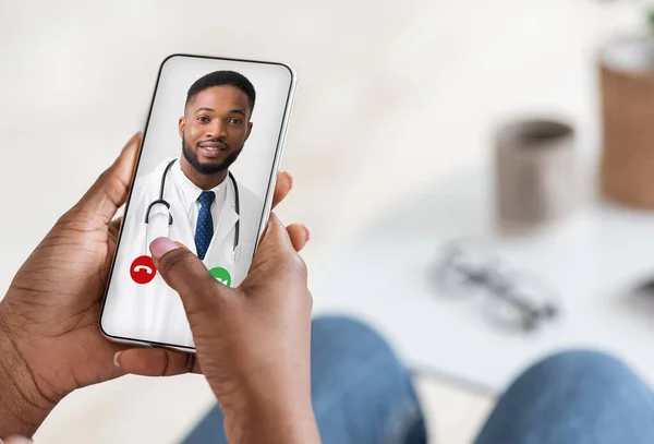 Soins médicaux à distance. Dame noire utilisant un téléphone intelligent, faire un appel vidéo avec le médecin — Photo