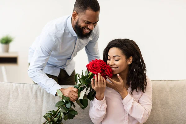 年轻的黑人男人送给女人一束红玫瑰 — 图库照片