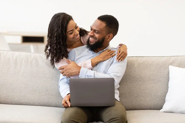 非洲裔美国人夫妇坐在沙发上，使用笔记本电脑 — 图库照片